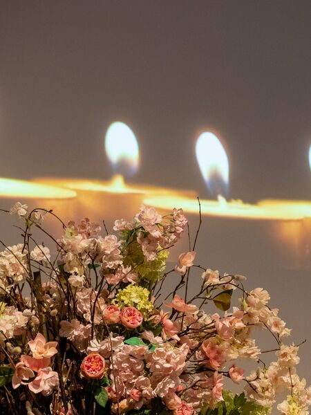 Sfeerbeeld aula uitvaartzorg Leo Ieper - Begrafenis aula met bloemen en kaarsen in Ieper.  - Over ons